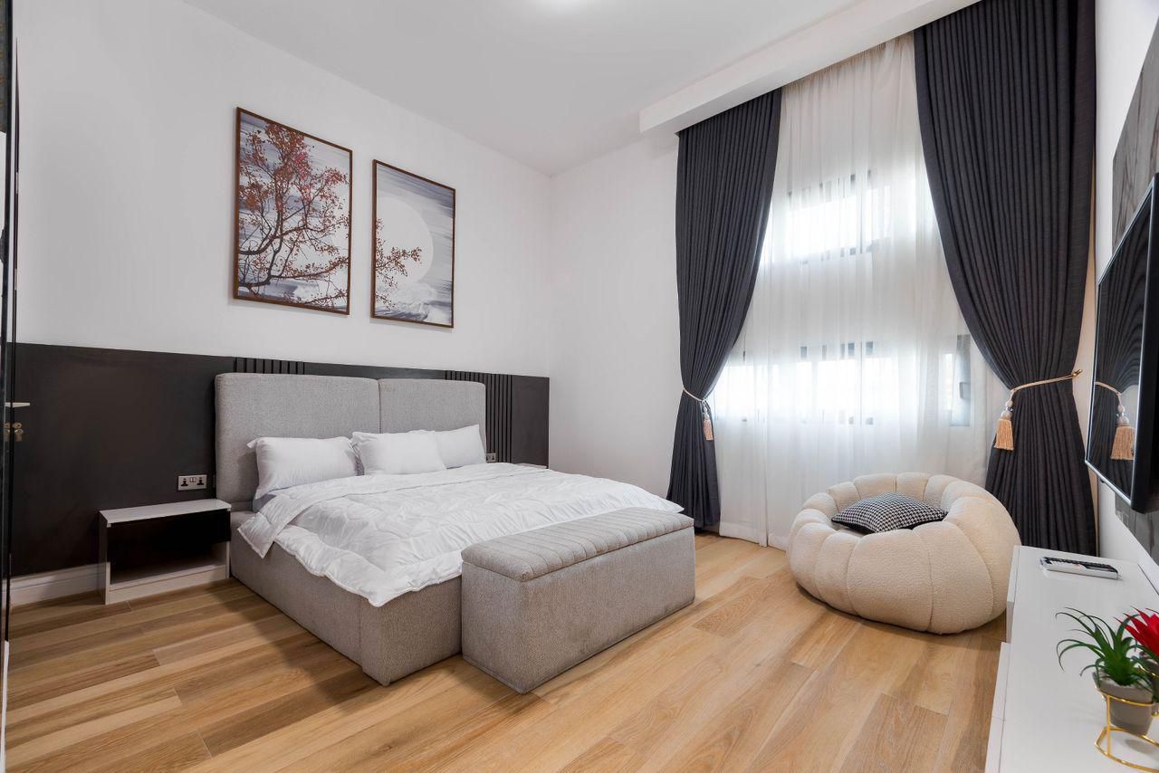 Bedroom with Bouclé Chair and Botanical Art