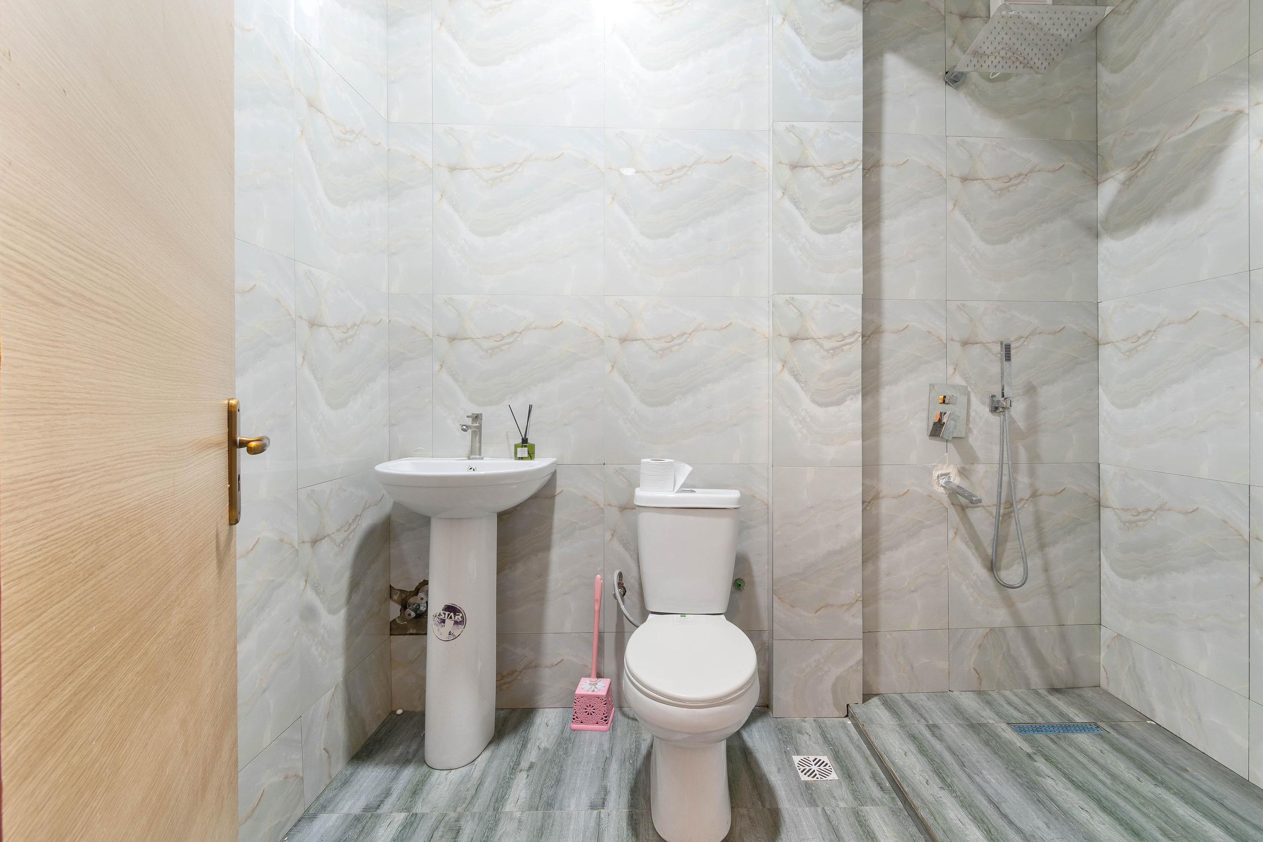 Marble-Clad Bathroom with Wood-Look Flooring
